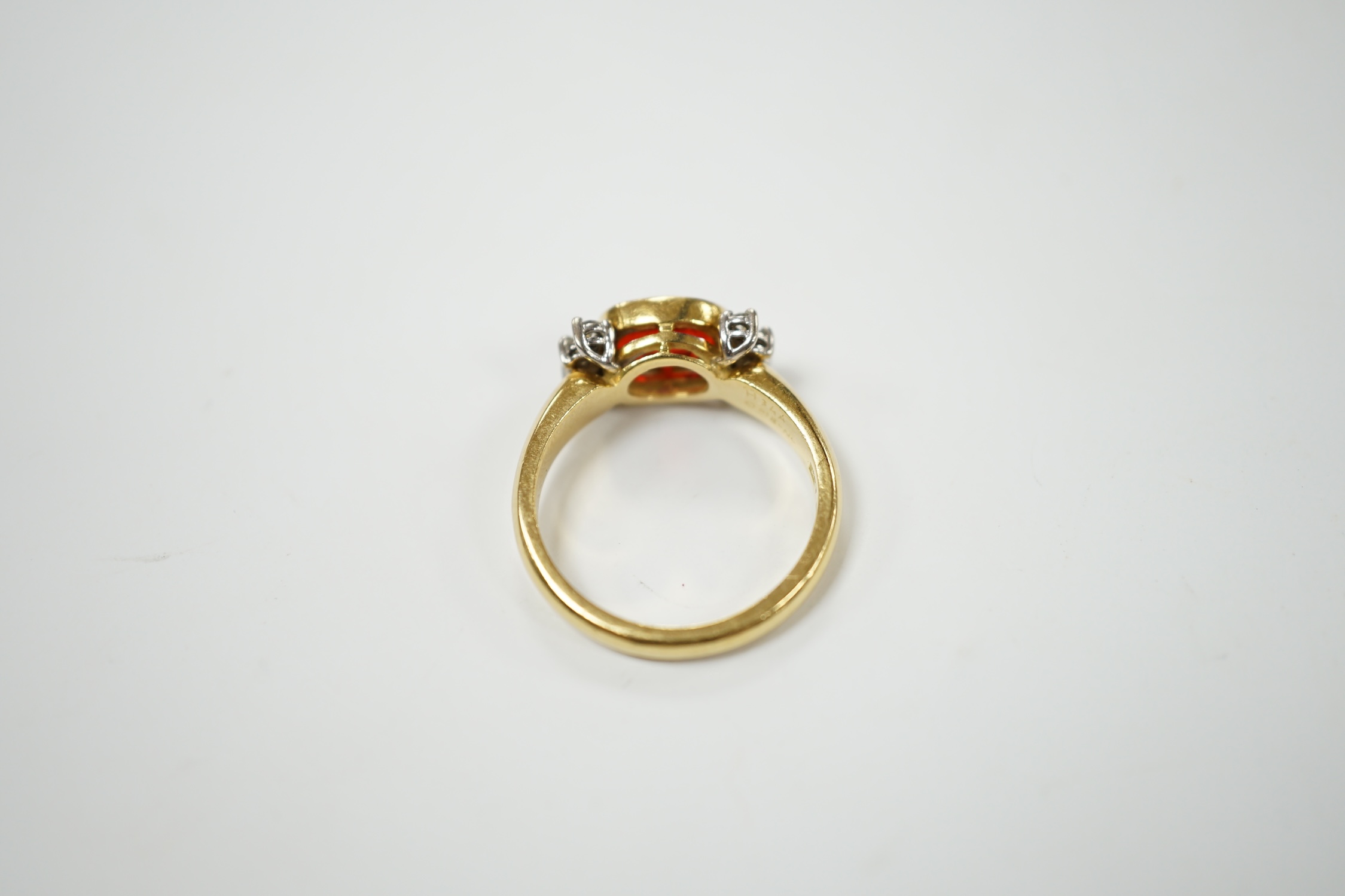 A modern 18ct gold, single stone fire opal? and eight stone diamond chip set dress ring, size L/M, gross weight 5.3 grams. Condition - fair to good